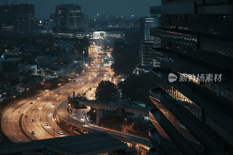 夜晚的Lebuh raya damansara高速公路，从高角度看，灯光照亮了道路上的雨水反射